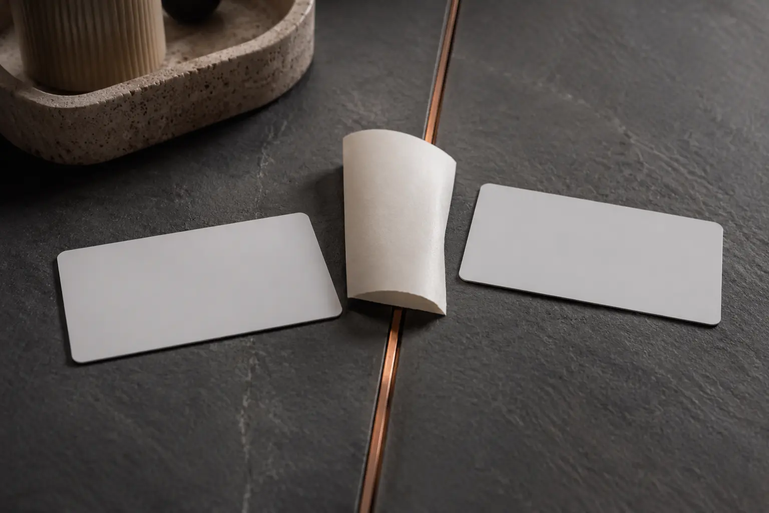 Two real blank wallet cards and one blank receipt edge meeting at a narrow copper line